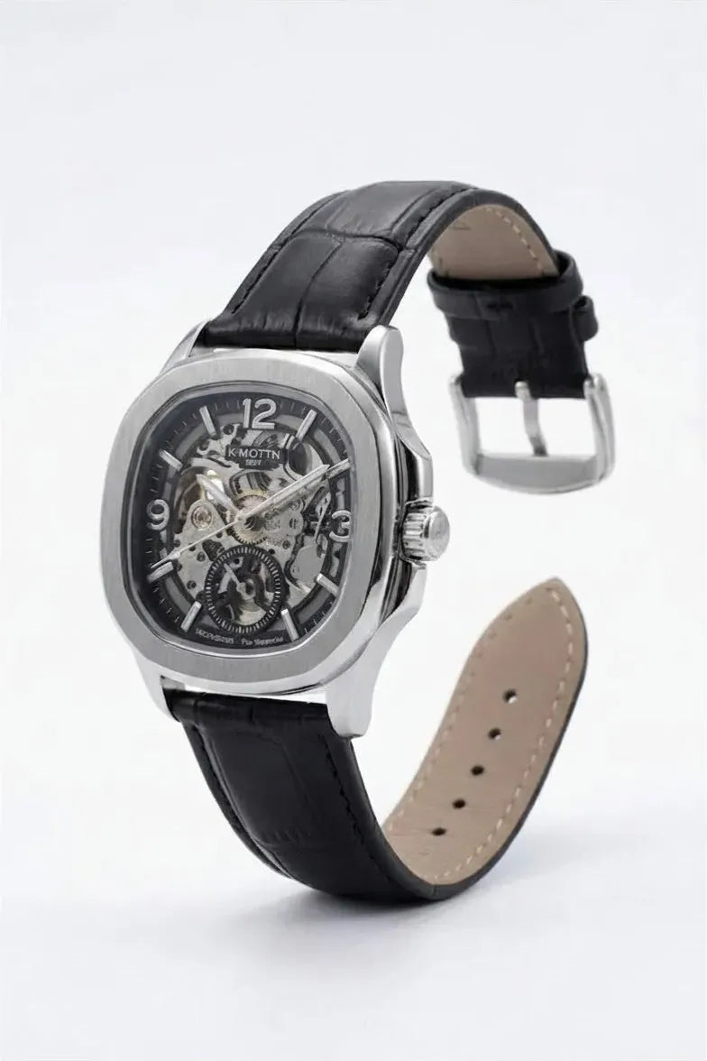 Silver-tone analog watch featuring an open-work skeleton dial.
